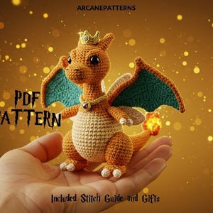 May include: A crocheted orange dragon with teal wings, a gold crown, and a flame on its tail. The dragon is held in a hand against a gold bokeh background. Text on the image reads "PDF PATTERN" and "Included Stitch Guide and Gifts".