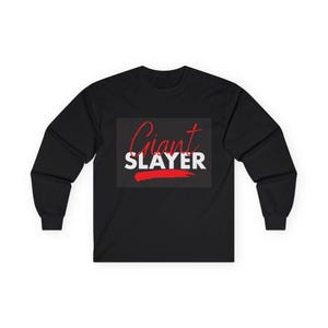 May include: Black long-sleeve shirt with the words "Giant Slayer" in a white and red design. The word "Giant" is in a cursive font, and "SLAYER" is in a bold, block font. A red brushstroke underlines the word "SLAYER".