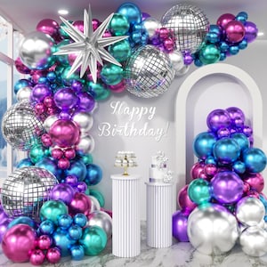 May include: A festive birthday party scene with a balloon arch in shades of pink, purple, teal, silver, and blue. The arch includes disco balls and a silver star. The words "Happy Birthday!" are displayed on the wall.