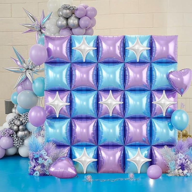Pu&ograve; includere: Un fondale decorativo con una griglia di palloncini quadrati iridescenti viola e blu, accentuati da decorazioni bianche a forma di stella. La scena comprende vari palloncini nelle tonalit&agrave; del viola, blu, argento e bianco, creando un'atmosfera festosa.