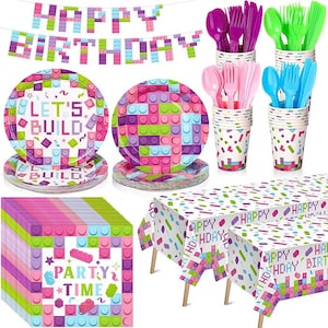 May include: A pink and purple birthday party set with a 'Let's Build' theme. The set includes plates, napkins, cups, a tablecloth, and a banner. The banner says 'Happy Birthday'.