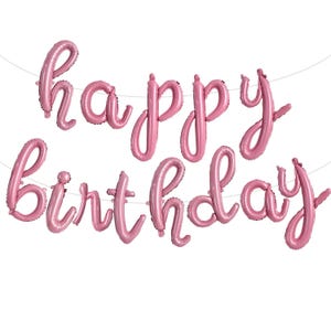 May include: Pink foil balloons spelling out "happy birthday" in a cursive font. The balloons are strung together on a thin white string, perfect for a birthday party decoration. The balloons are a soft, pastel pink color.