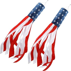 May include: Two American flag-themed windsock decorations. Each windsock features a blue top with white stars, red and white stripes, and flowing red and white ribbons. The windsocks are designed to hang and catch the wind.