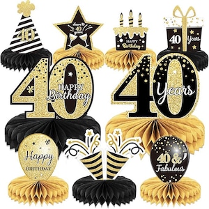 May include: A collection of black and gold 40th birthday decorations. Includes honeycomb centerpieces, star and cake toppers, and balloon accents. The decorations feature the text "Happy Birthday", "40 Years", and "40 & Fabulous".