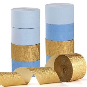 May include: Two stacks of crepe paper rolls in light blue, medium blue, and gold. A gold crepe paper roll is unrolled in the foreground. The paper has a textured, crinkled appearance. Perfect for party decorations or craft projects.