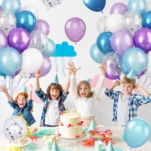 Puede incluir: Escena de fiesta de cumplea&ntilde;os con ni&ntilde;os y globos coloridos. La imagen presenta una tarta, globos en tonos azules, morados y blancos, y decoraciones de fiesta. Los ni&ntilde;os levantan los brazos, creando un ambiente alegre.