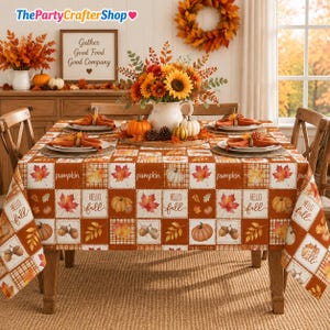May include: A rectangular tablecloth featuring a grid pattern of autumn-themed squares with illustrations of pumpkins, acorns, and maple leaves, alongside text reading "pumpkin" and "hello fall" in a brown, orange, and white color palette.