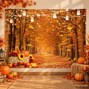 May include: A backdrop featuring a forest path with orange autumn leaves, illuminated by hanging string lights. In the foreground, hay bales are decorated with orange pumpkins, sunflowers, and red flowers, creating a seasonal display.