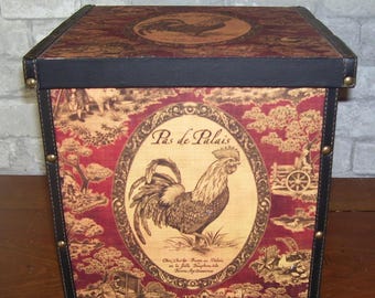 May include: A red and gold storage box with a rooster design and the text "Pas de Palais". The box has a black leather trim and metal accents.