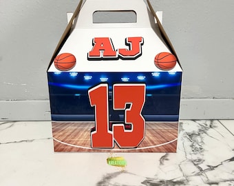 May include: A white basketball-themed gift box with a handle. The box features the letters "AJ" and the number "13" in orange, along with basketball graphics. The box is decorated with a basketball court design.