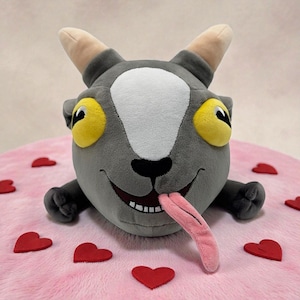 Könnte beinhalten: Eine weiße Keramik-Tasse mit schwarzem Henkel und dem Text "But First, Coffee" in schwarzer, handschriftlicher Schrift. Die Tasse steht auf einer weißen Oberfläche.