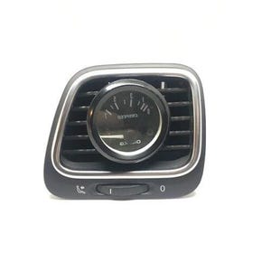 Può includere: Una presa d'aria nera del cruscotto dell'auto con finiture argentate. Un indicatore rotondo è centrato all'interno della presa d'aria, che mostra numeri e segni. La presa d'aria ha un piccolo interruttore di controllo e un contrassegno numerico.