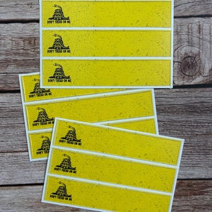 May include: Six yellow rectangular stickers with a black rattlesnake and the text "Don't Tread On Me".