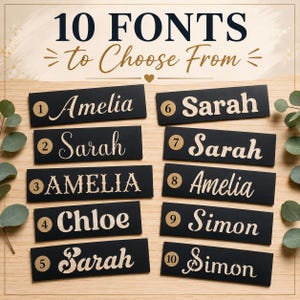 May include: A display of 10 rectangular black signs featuring various white font styles for names. Each sign is numbered from 1 to 10 in a gold circle. The text at the top reads 10 FONTS to Choose From. The signs are arranged on a light wood surface.