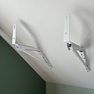 a pair of white brackets on a white ceiling