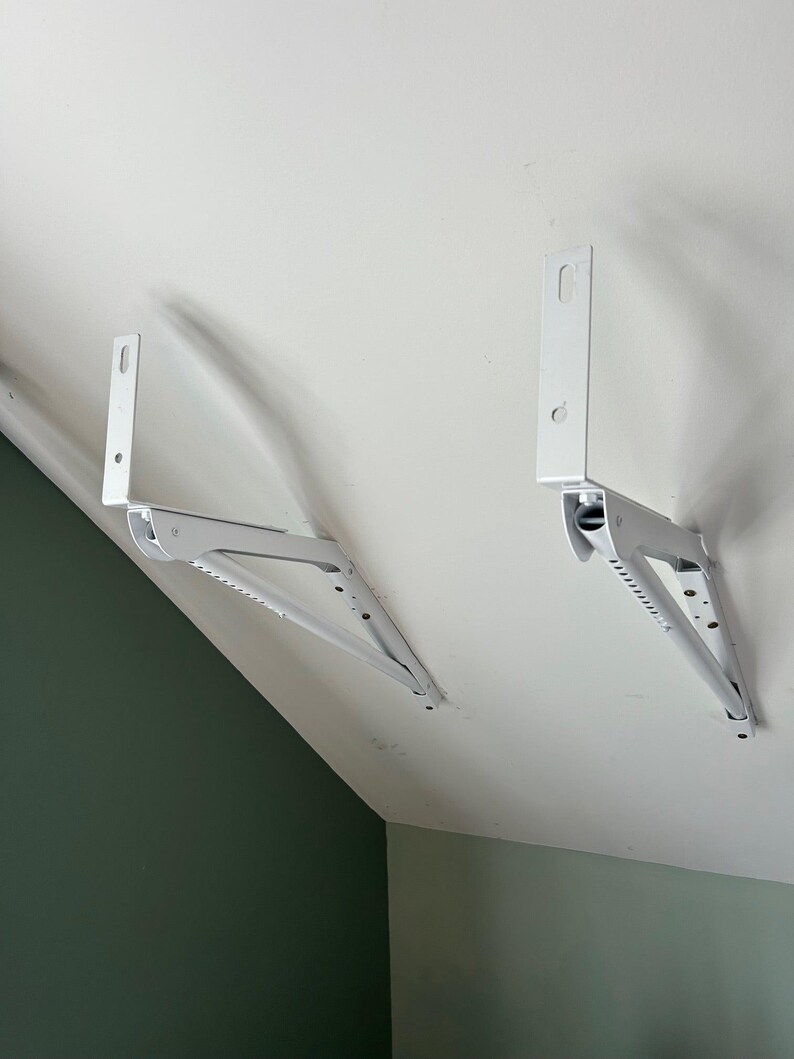 a pair of white brackets on a white ceiling