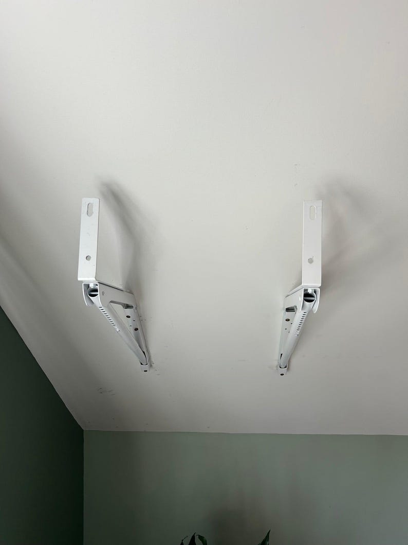 a pair of white brackets on a white ceiling