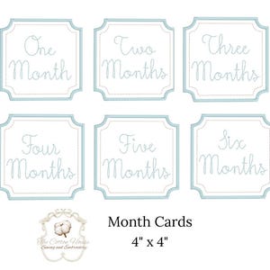 May include: Set of six baby month cards, each 4" x 4", with embroidered text in a light blue frame. The cards read "One Month" through "Six Months". The Cotton House Sewing and Embroidery logo is at the bottom.
