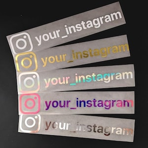 Könnte beinhalten: Fünf Instagram-Logo-Aufkleber mit dem Text "your_instagram" in verschiedenen Farben. Die Logos sind in Weiß, Gold, schillernd, Rosa und Silber gehalten. Die Aufkleber befinden sich auf einer transparenten Folie.