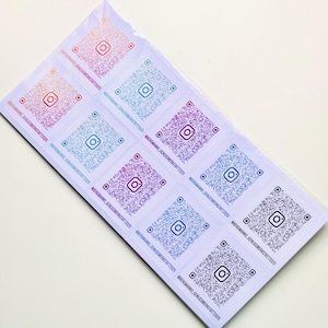 Könnte beinhalten: Ein Bogen weißer Aufkleber mit Instagram-QR-Codes in verschiedenen Farben. Jeder Aufkleber hat ein quadratisches Instagram-Logo in der Mitte des QR-Codes und den Text "@BERGMANNS_GENUSSWERKSTATT2025" darunter.