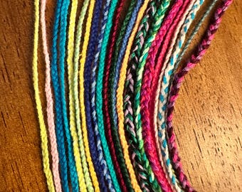 May include: A collection of colorful embroidery floss spools arranged in a rainbow pattern. The floss is made of cotton and is perfect for crafting projects.