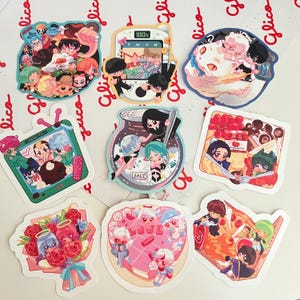 May include: A collection of colorful anime-style stickers featuring various designs. The stickers depict characters in different settings, including a TV, a jar with salt, a phone, a cat, a bouquet of roses, a heart-shaped cake, and a pizza. The stickers are on a white surface.