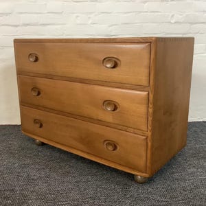 Può includere: Un set di tre tazze in ceramica con finitura opaca e macchiettata. Le tazze sono nei toni del crema, grigio chiaro e grigio scuro. Ogni tazza ha un design semplice e minimalista.