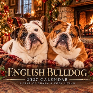 May include: A 2027 calendar titled English Bulldog A Year of Charm & Cozy Living featuring a photograph of two English Bulldogs with white and brown fur lying together on a plaid bed in front of a fireplace and Christmas tree.