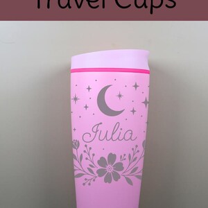 A dreamy custom name coffee cup with moon and star accents paired with delicate florals, creating a unique celestial-inspired drinkware piece that blends beauty and function.Styled product shot of a personalized SmoothSip tumbler with custom name text and floral celestial artwork, placed among cozy decor to highlight its warm, giftable appeal.