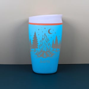 Personalized travel coffee cup designed with a whimsical outdoor camping scene and celestial starry night details. This engraved Owala SmoothSip makes a beautiful custom gift for her, blending practical drinkware with cozy campfire energy, nature-inspired style, and personalized charm.