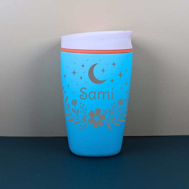 A close-up view of a custom name coffee tumbler with etched-style floral details and celestial accents, creating a magical and personalized gift perfect for her birthday or special occasion.