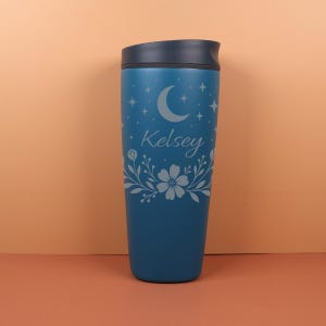 Flat lay of a personalized SmoothSip bottle with custom name text and celestial artwork, including stars and crescent moons, styled with dried flowers to emphasize its boho, whimsigoth aesthetic.