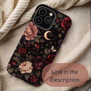 May include: A black phone case with a floral design featuring roses, peonies, and other flowers in shades of red, pink, and purple. The case also includes a gold crescent moon, stars, and a butterfly. The text "Link in the Description" is visible.