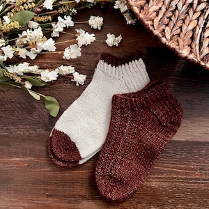 Pode incluir: Dois pares de meias de tricô, um par é branco com uma bainha marrom e o outro par é marrom com uma bainha marrom.