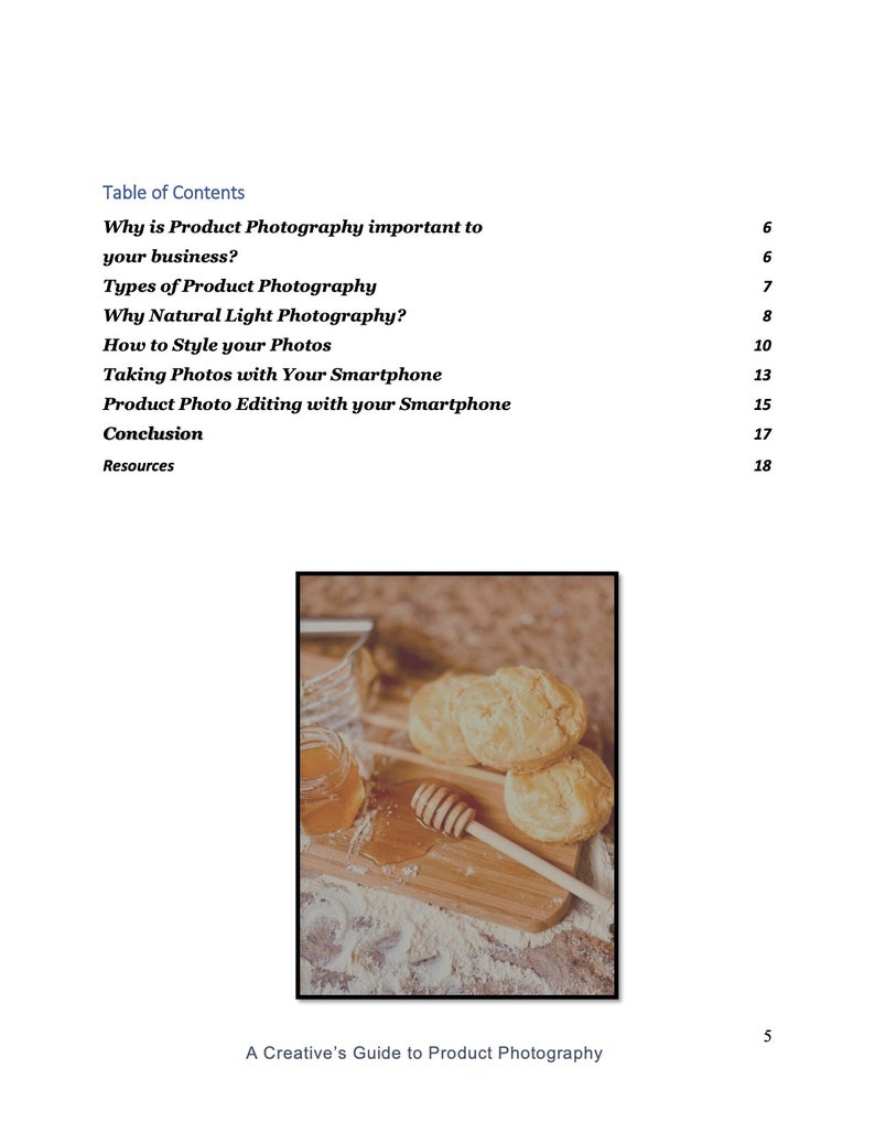 May include: A close-up of a wooden cutting board with three golden brown biscuits, a jar of honey, and a honey dipper. The biscuits are arranged in a stack, and the honey is drizzled over the top biscuit. The cutting board is covered in a light dusting of flour.