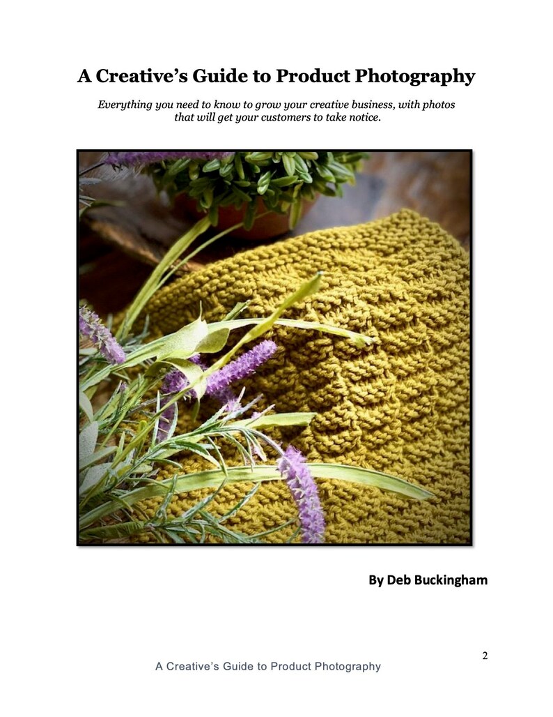 May include: A close-up of a knitted yellow dishcloth with purple flowers on top. The dishcloth is made with a textured stitch pattern.