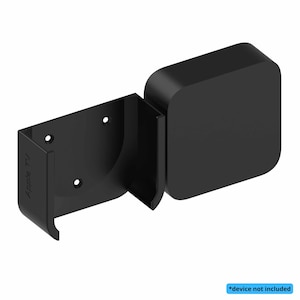 Può includere: Supporto a parete nero per Apple TV. Il supporto è realizzato in plastica e ha una staffa per contenere il dispositivo Apple TV. Il testo "Apple TV" è visibile sul lato del supporto. Il dispositivo non è incluso.