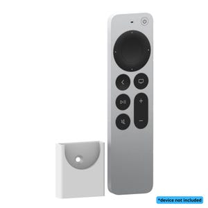 Puede incluir: Un mando a distancia plateado con un panel de control circular negro y varios botones. A la izquierda hay un soporte rectangular blanco. El texto "*device not included" está en un cuadro azul en la parte inferior derecha.