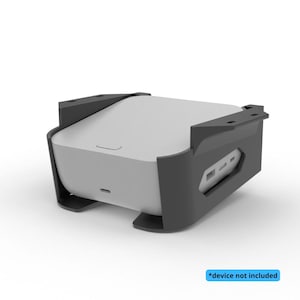 Könnte beinhalten: Ein graues Gerät mit gewölbter Oberseite wird in einer schwarzen Halterung gehalten. Die Halterung hat eine rechteckige Form mit Aussparungen an der Seite. Der Text "*device not included" befindet sich in einem blauen Rechteck.