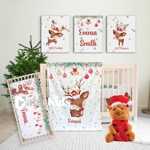 May include: A festive nursery set with a Christmas theme. The set includes a cot, bedding, and wall art featuring a reindeer design. The artwork includes the name "Emma" and the phrases "Hello Winter" and "Let It Snow". A plush reindeer toy is also included.