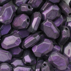 May include: A collection of faceted, oblong beads in a deep purple hue. Each bead has a glossy finish and a hole for stringing. The beads are irregularly shaped, with multiple flat surfaces. These beads are suitable for jewelry making.