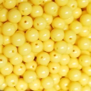 May include: A close-up image of a pile of bright yellow round beads. The beads are smooth and glossy.