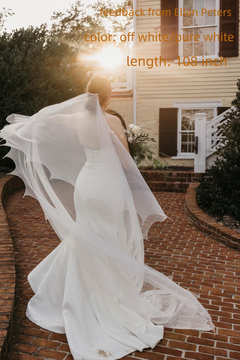 May include: A floor-length off-white or pure white wedding veil with a scalloped edge, measuring 274.32 cm in length. The veil is sheer and lightweight, featuring a delicate pattern along the border, shown with feedback from Ellen Peters.