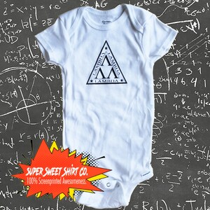 May include: A white babygrow with a black triangular logo featuring the word "LAMBDA" repeated three times. The babygrow is against a black chalkboard background with white mathematical equations.