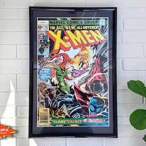 May include: A framed vintage Marvel Comics X-Men issue 105 comic book cover featuring colourful illustrations of Phoenix, Firelord, and other characters with the bold yellow X-Men logo at the top and the text Flame Frenzy Firelord at the bottom.