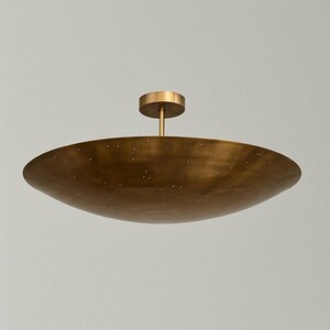 Puede incluir: Una l&aacute;mpara de techo en forma de cuenco de color lat&oacute;n. La l&aacute;mpara tiene una base circular y un v&aacute;stago que se conecta a un cuenco grande y poco profundo. Peque&ntilde;as perforaciones salpican la superficie del cuenco. La l&aacute;mpara est&aacute; dise&ntilde;ada para uso en interiores.