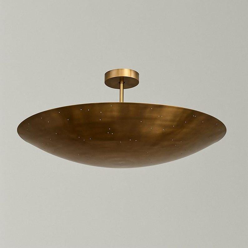 Puede incluir: Una l&aacute;mpara de techo en forma de cuenco de color lat&oacute;n. La l&aacute;mpara tiene una base circular y un v&aacute;stago que se conecta a un cuenco grande y poco profundo. Peque&ntilde;as perforaciones salpican la superficie del cuenco. La l&aacute;mpara est&aacute; dise&ntilde;ada para uso en interiores.