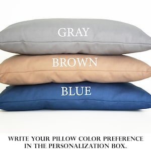 Puede incluir: Tres almohadas rectangulares apiladas. La almohada superior es gris, la almohada del medio es marr&oacute;n y la almohada inferior es azul. El texto de la imagen dice "GRAY", "BROWN" y "BLUE". El texto en la parte inferior dice "WRITE YOUR PILLOW COLOR PREFERENCE IN THE PERSONALIZATION BOX."