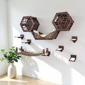 May include: A wooden cat furniture set, including a bridge, hexagon-shaped cat houses, and small platforms, mounted on a white wall. The cat bridge is made of wood and rope. The cat houses feature leaf-shaped cutouts. The set is designed for cats.