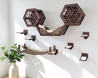 May include: A wooden cat furniture set with a bridge, hexagon-shaped cat houses, and small platforms. The set is mounted on a white wall. The cat bridge is made of wood and rope. The cat houses have leaf-shaped cutouts.